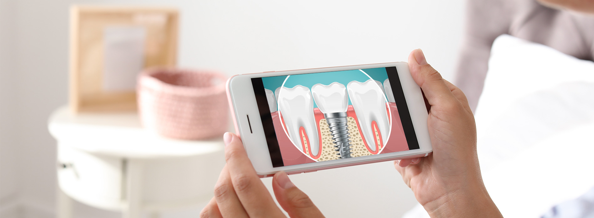 This is a photograph of a person holding a smartphone displaying an image of a toothbrush with bristles and paste, against a blurred background that suggests a domestic setting.